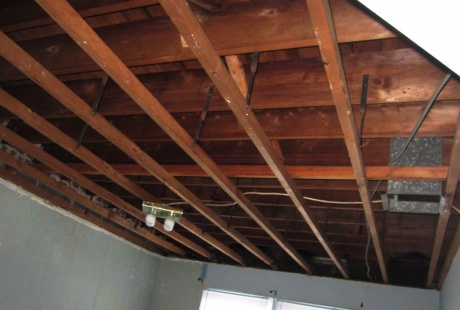 Basement ceiling drywall removed after water damage restoration