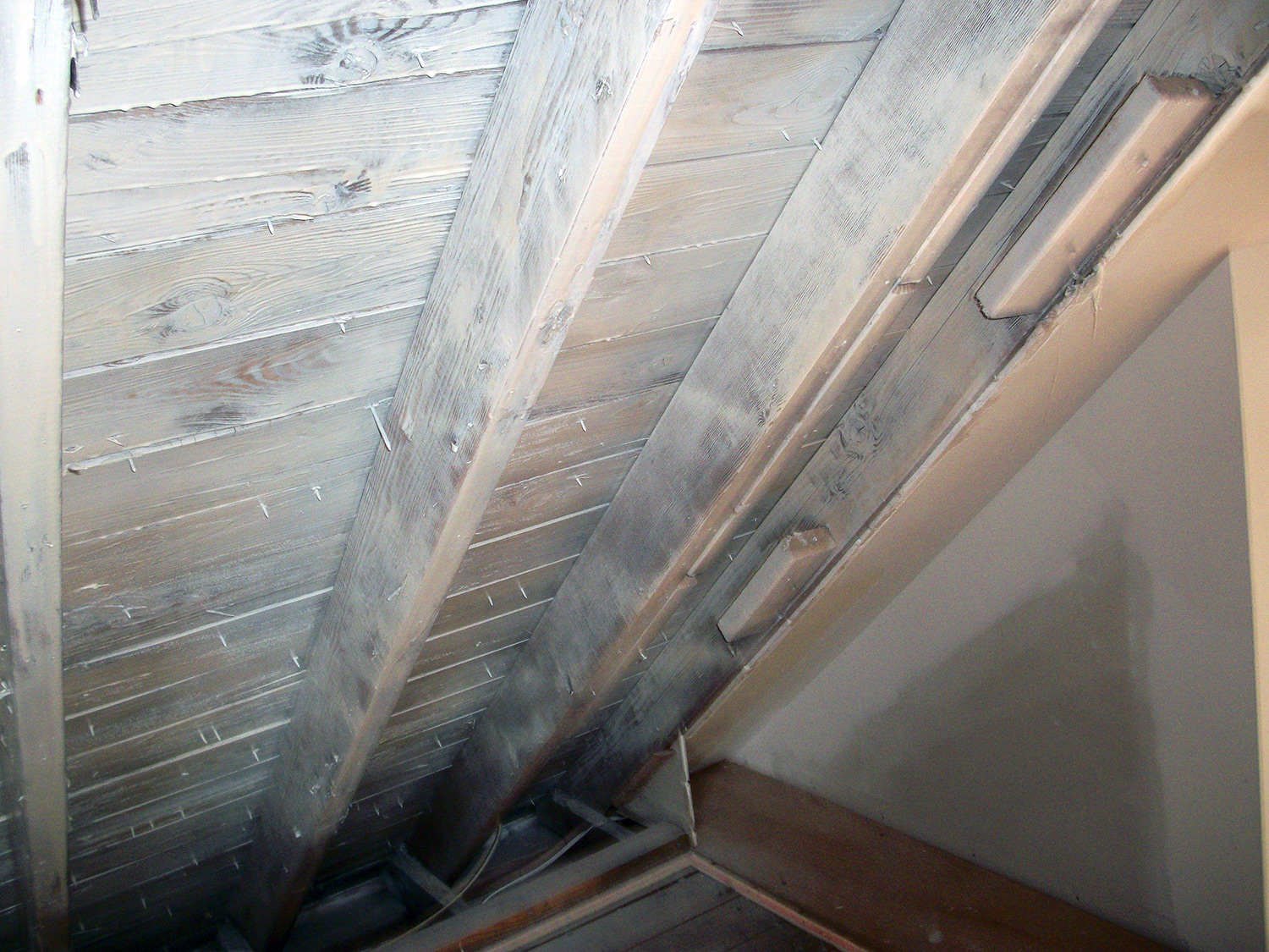 Water damage removed from roofing boards in the attic with anti-mold coating
