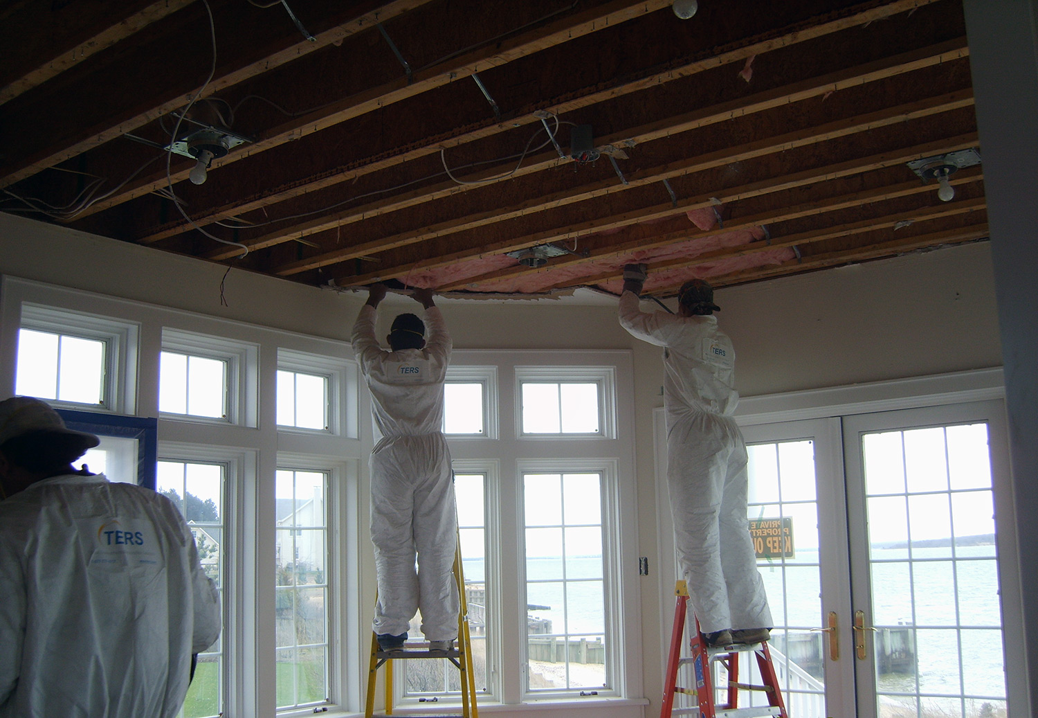TERS mold and water remediation crew removing contaminated wood, drywall, and insulation from the ceiling