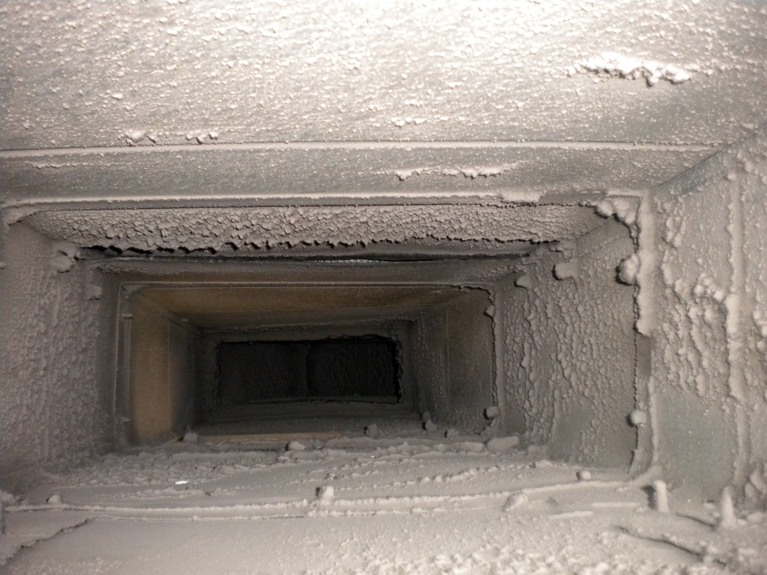 Air duct covered in dust and debris before being cleaned
