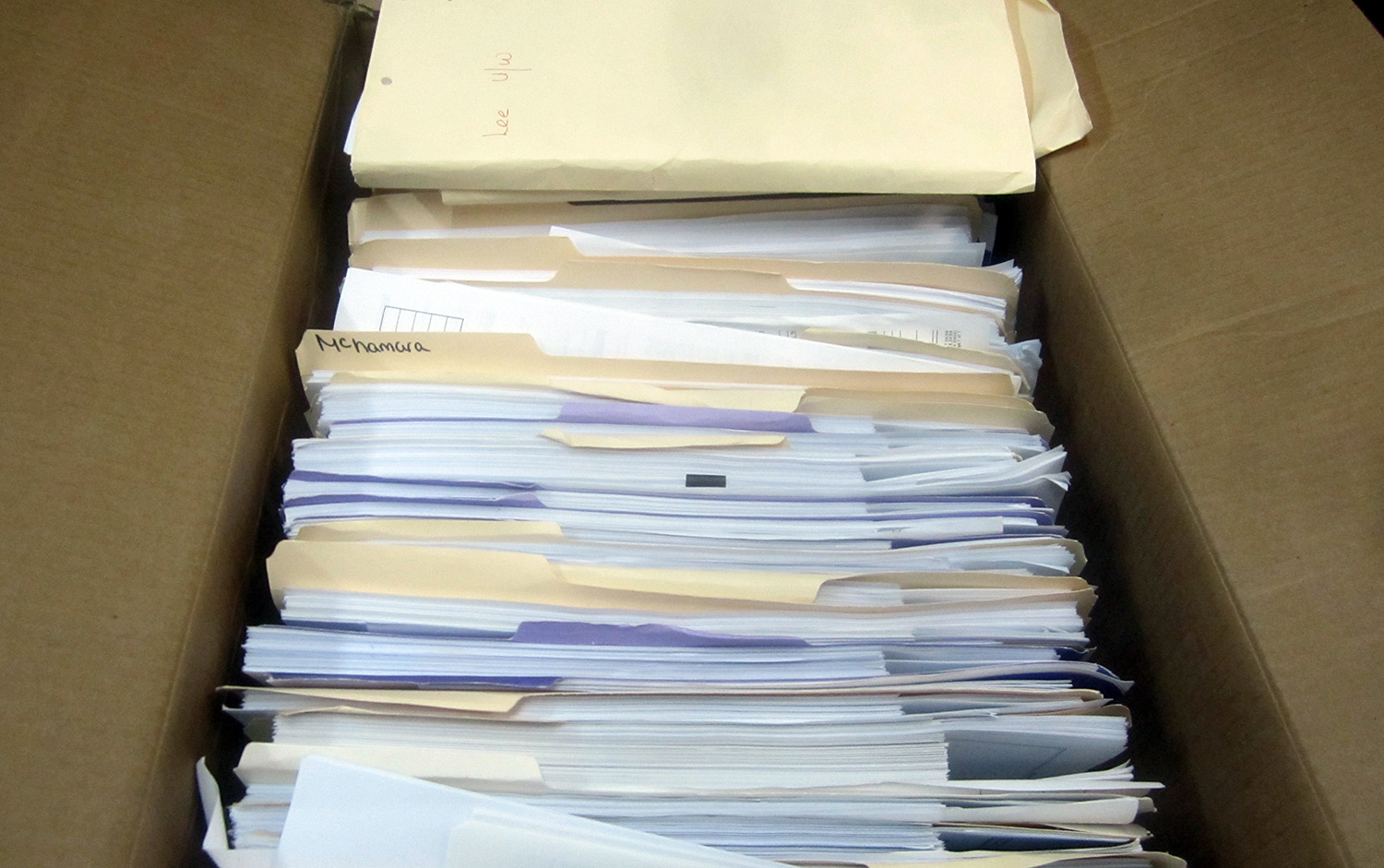 Restored paper documents neatly placed in folders in a box after TERS document restoration